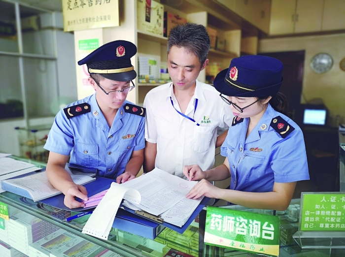 執(zhí)法人員在一家藥店檢查特殊藥品進貨臺賬。