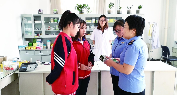 圖為執(zhí)法人員向?qū)W生普及安全用藥知識(shí)。