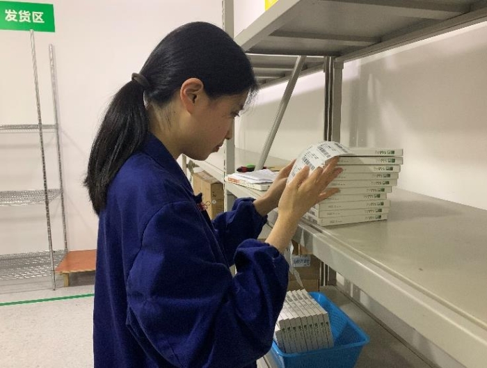 圖為金華市中心醫(yī)院工作人員將追溯二維碼粘貼到醫(yī)療器械包裝盒上。何璇 攝