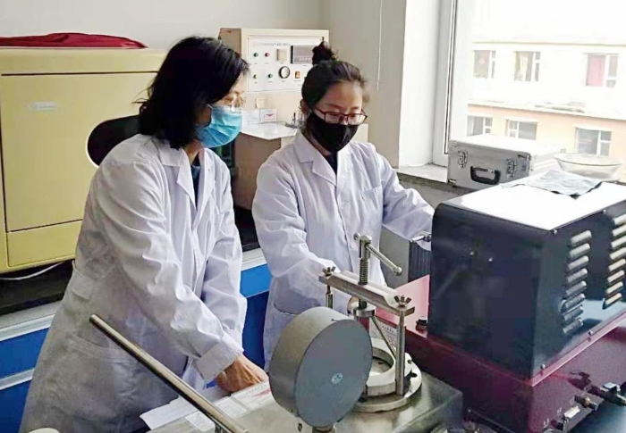 圖為吉林省器械所檢驗人員進行醫(yī)用一次性口罩的項目檢驗。