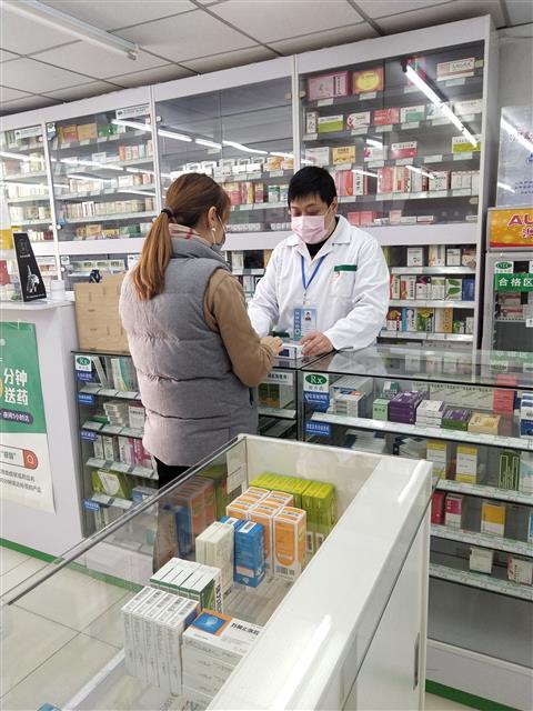 疫情防控時期，魏駿在藥店為顧客提供藥學(xué)服務(wù)。