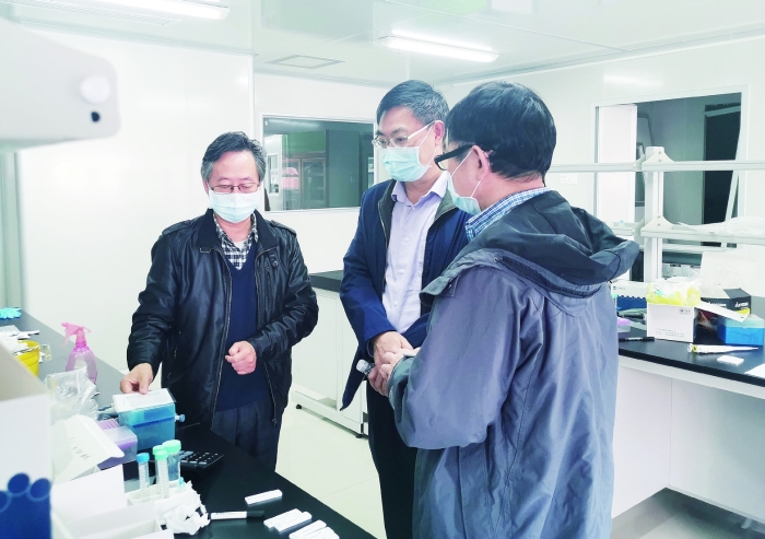 2月23日，廣東省藥監(jiān)局副局長嚴振（中）率隊到廣東和信健康科技有限公司幫助企業(yè)解決新冠病毒檢測試劑注冊申報問題。 王天才 攝
