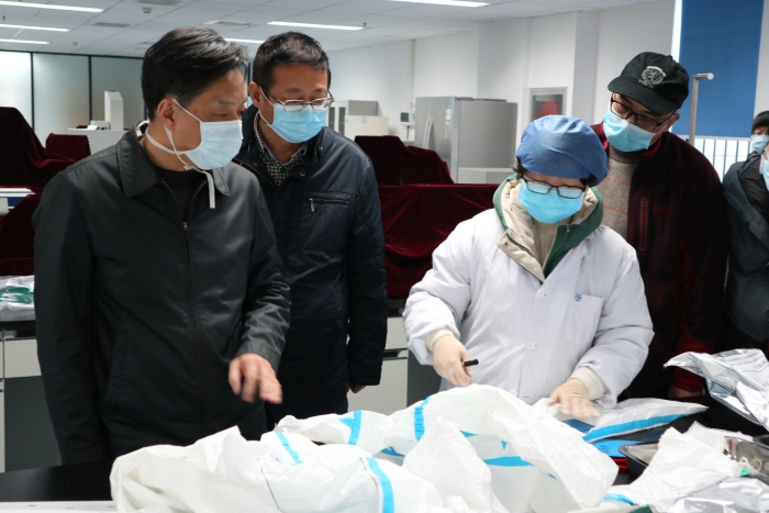 圖為湖北省藥監(jiān)局鄧小川（左一）帶領武漢分局執(zhí)法人員對防護用品生產(chǎn)企業(yè)進行現(xiàn)場檢查。（湖北省藥監(jiān)局武漢分局供圖）