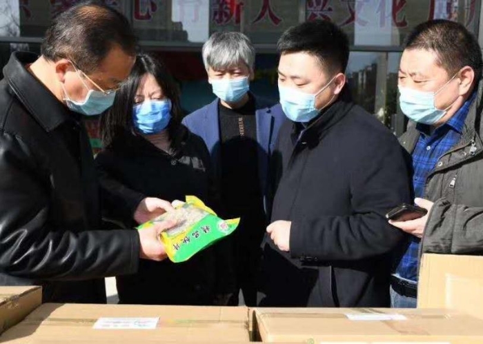 張艷琴（左二）接受企業(yè)捐贈(zèng)抗疫物資。
