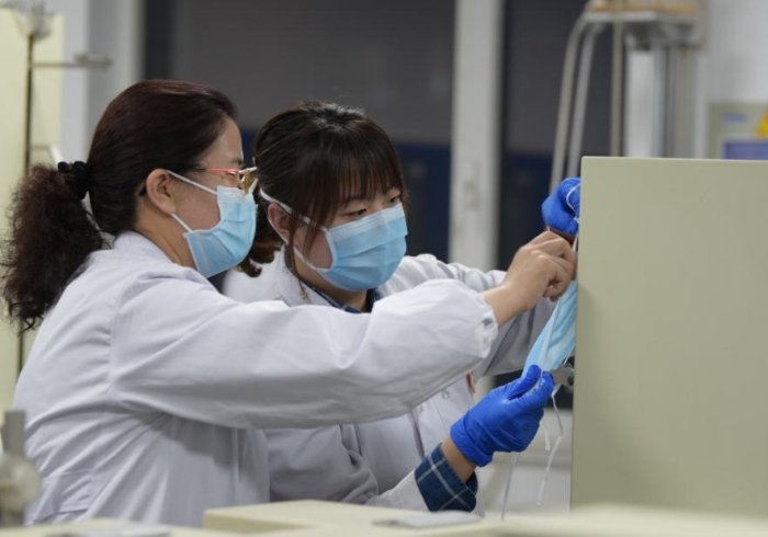 技術(shù)人員對(duì)口罩等疫情防控用品進(jìn)行檢驗(yàn)。