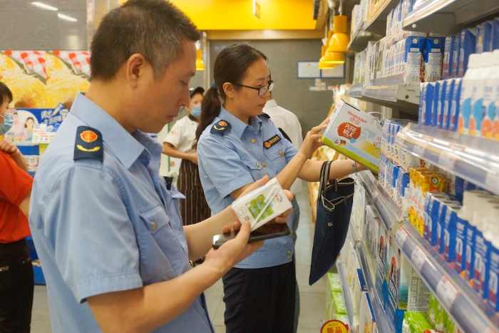 執(zhí)法人員在一家超市檢查乳制品質(zhì)量 執(zhí)法人員在一家超市檢查乳制品質(zhì)量