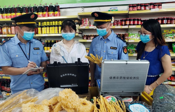 圖為6月21日該局執(zhí)法人員正在一超市檢測食品。