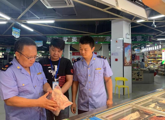 圖為該局執(zhí)法人員在一家農(nóng)貿(mào)市場冷凍食品專柜進(jìn)行檢查。