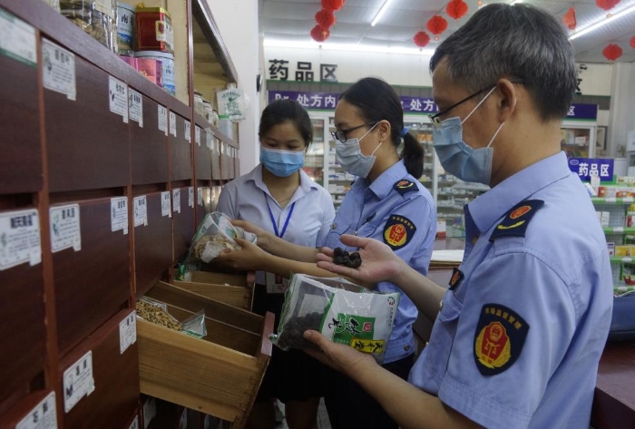 圖為執(zhí)法人員在一家零售藥店檢查中藥飲片。