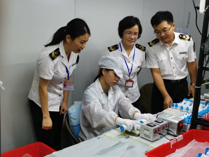 工作人員在檢查紅外體溫計、口罩生產(chǎn)企業(yè)。