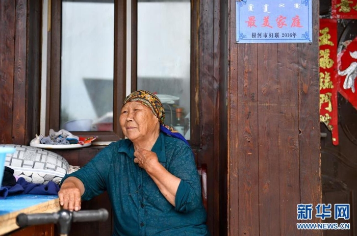 中妮浩坐在位于敖魯古雅鄂溫克族鄉(xiāng)的家門口休息（7月14日攝）。 新華社記者 貝赫 攝