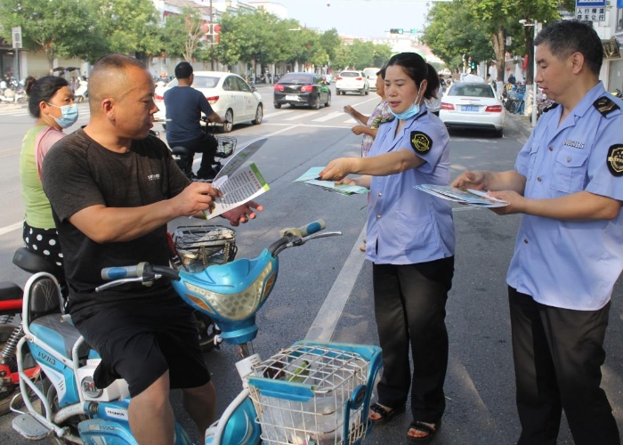 圖為該局執(zhí)法人員在縣城人民路向行人發(fā)放食品安全宣傳材料。