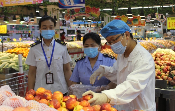 圖為該局執(zhí)法人員在一商場抽取食品樣品送檢。