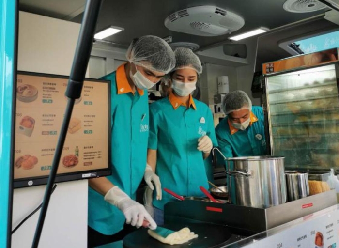 “逸小兔”流動早餐車的店員正在為顧客備餐。新華網(wǎng)發(fā)（熊多多 攝）