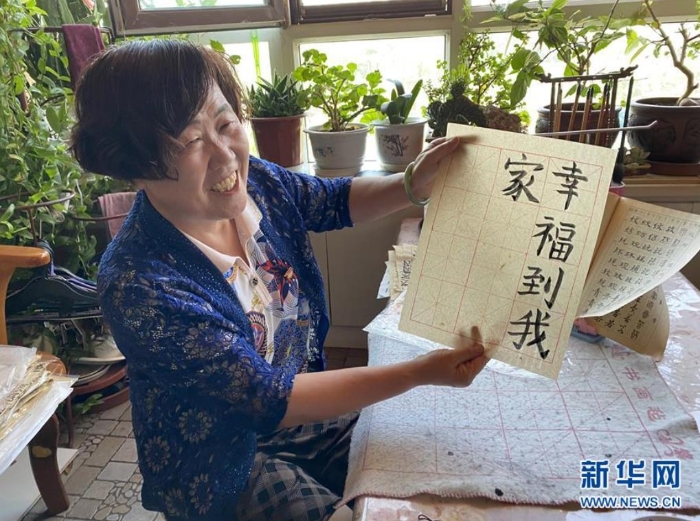 袁秀梅在自家書(shū)房寫(xiě)下“幸福到我家”幾個(gè)字（8月18日攝）。 新華社記者 汪亞 攝