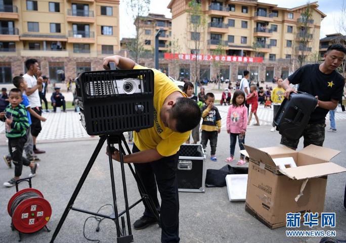 搬下山的人們，住進了有彝族傳統(tǒng)建筑風格的新社區(qū)，每隔一段時間就會有縣里的放映隊為這里的群眾放露天電影（8月11日攝）。 新華社記者 李賀 攝