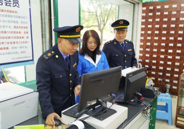 圖為執(zhí)法人員在查看藥店處方藥銷售臺賬。