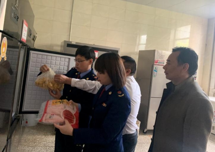圖為該局執(zhí)法人員檢查學(xué)校食堂食品原料。