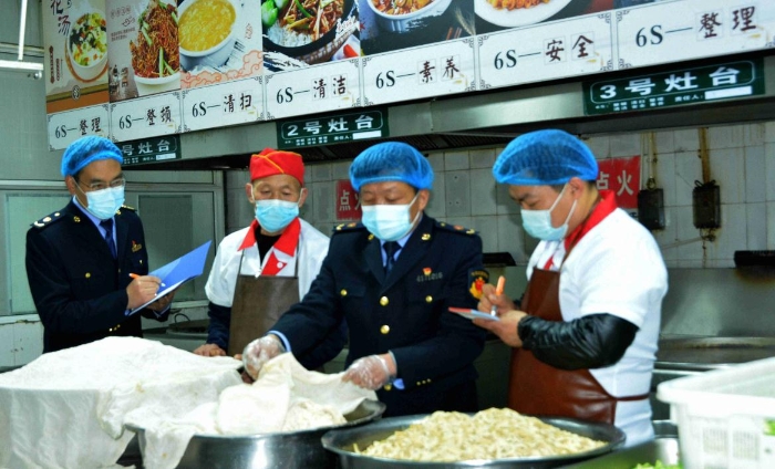 圖為4月7日，執(zhí)法人員在檢查某學校食堂操作間衛(wèi)生。