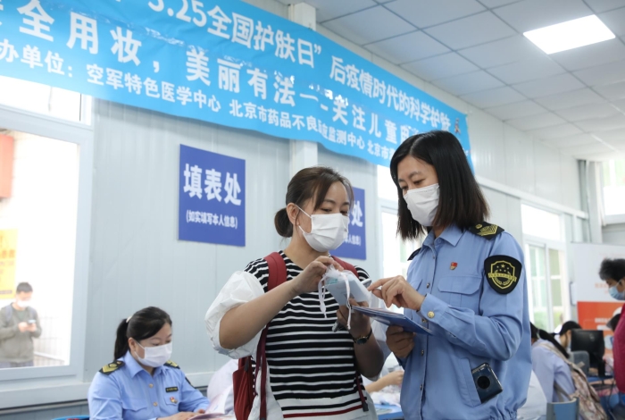 圖 海淀區(qū)市場監(jiān)管局監(jiān)管人員在中國人民解放軍空軍特色醫(yī)學中心為消費者講解化妝品安全事項。