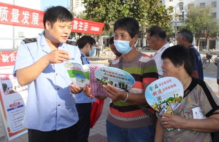 圖為執(zhí)法人員向群眾宣講食品安全知識(shí)。