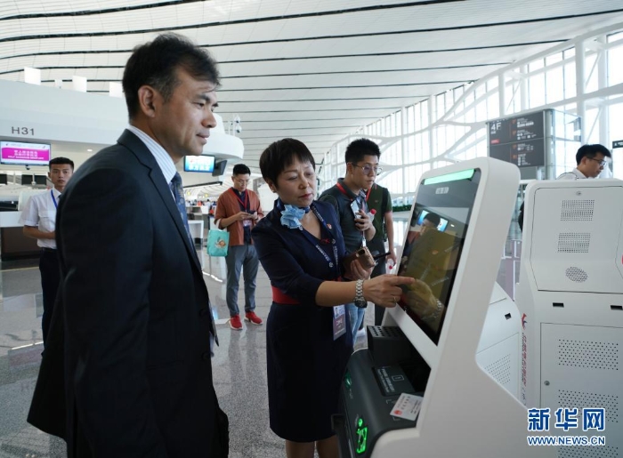 中國東方航空公司工作人員（前左二）在指導(dǎo)乘客通過“人臉識別”辦理值機手續(xù)（2019年9月25日攝）。新華社記者 鞠煥宗 攝