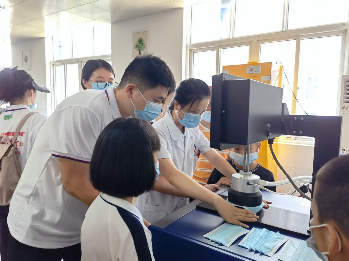 圖為技術(shù)人員在講解口罩的檢驗(yàn)方法和原理。（喻燦華 攝）