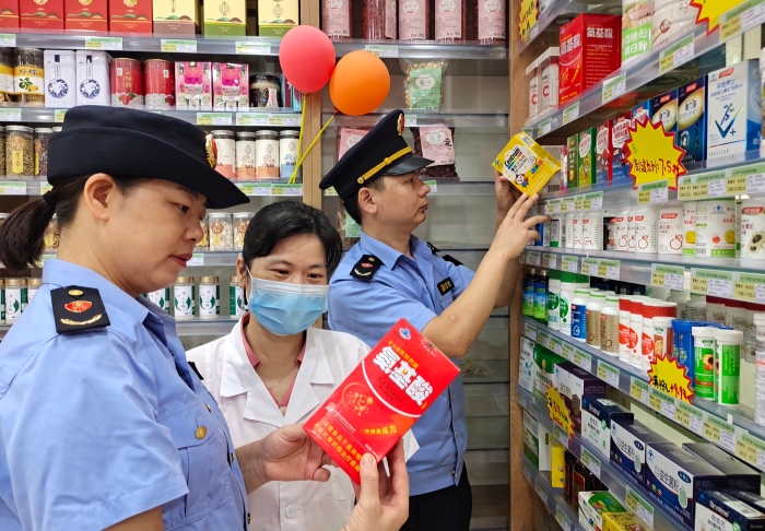圖為7月26日執(zhí)法人員檢查保健食品標簽標識。