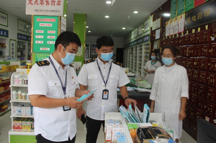 圖為執(zhí)法人員在一家藥店檢查口罩產(chǎn)品質(zhì)量。