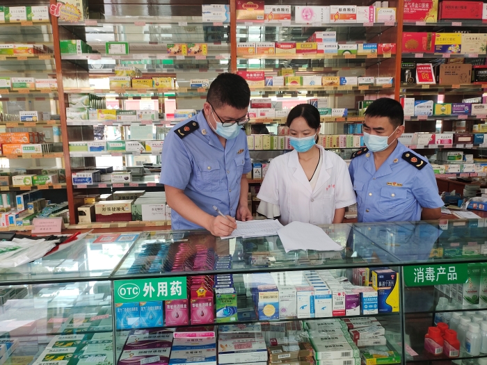圖為監(jiān)管人員在一家藥店核對退燒、抗病毒等藥品銷售登記本。