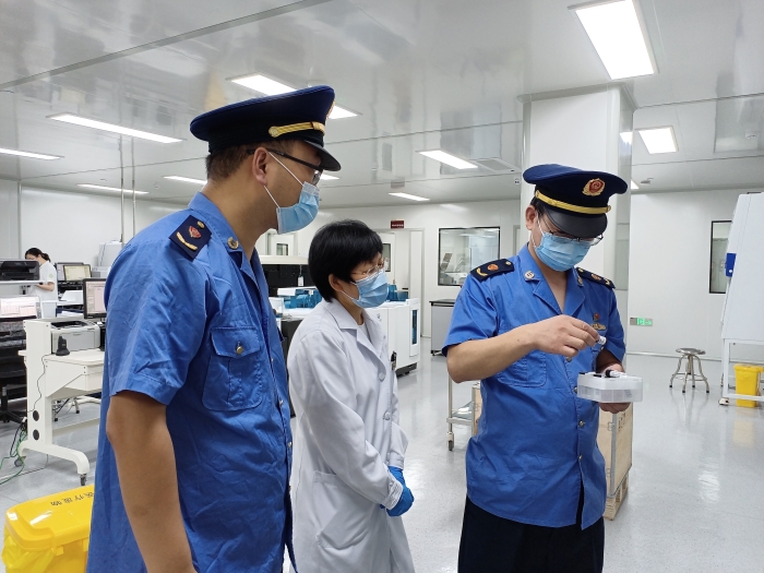 圖為執(zhí)法人員在一家醫(yī)療機構(gòu)檢查新冠病毒檢測試劑使用情況。