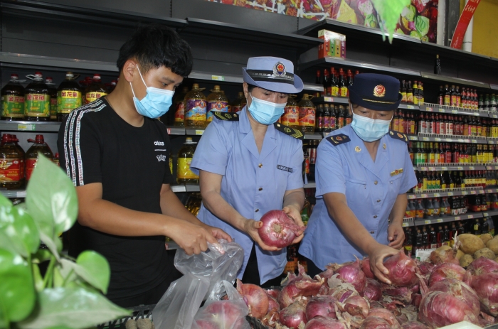 圖為執(zhí)法人員和檢測機構工作人員抽取蔬菜樣品送檢。