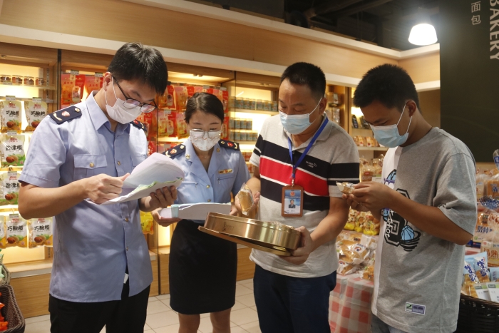 圖為執(zhí)法人員查看月餅質(zhì)量情況。（柯潔 攝）