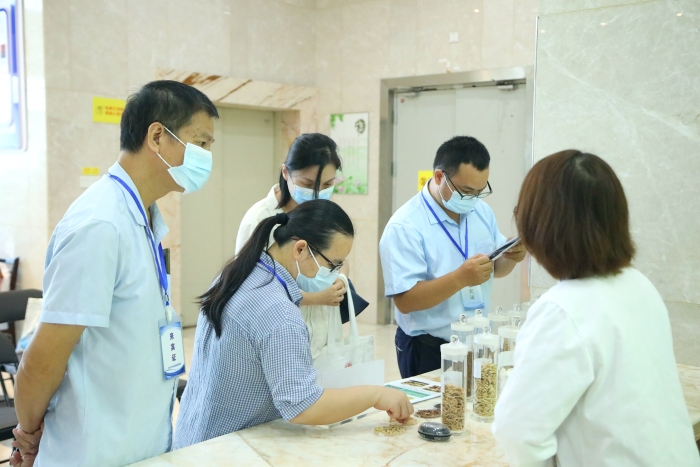 圖為工作人員向市民代表講解中藥材（枸杞、菊花等）真?zhèn)舞b別知識(shí)。