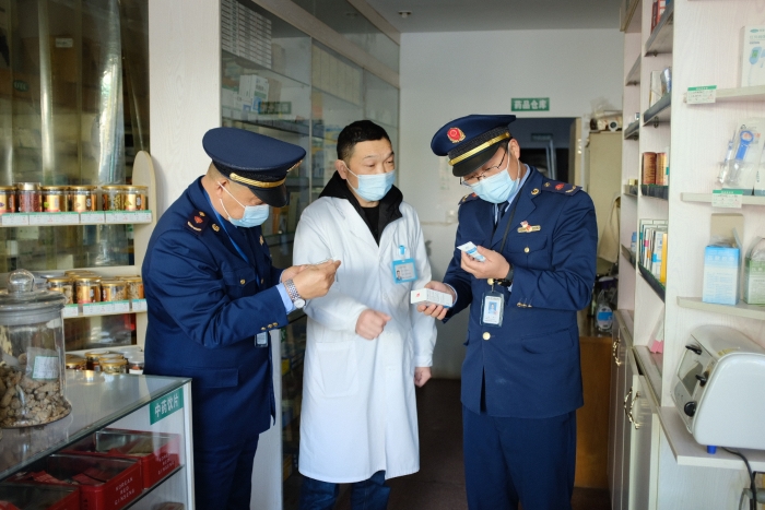 圖為執(zhí)法人員在一家藥店檢查其經(jīng)銷的藥品外包裝上標簽是否規(guī)范，并核對相關購銷登記臺賬的信息是否合規(guī)。