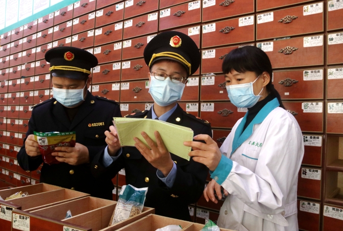 圖為11月24日執(zhí)法人員對一家藥店檢查中藥飲片。