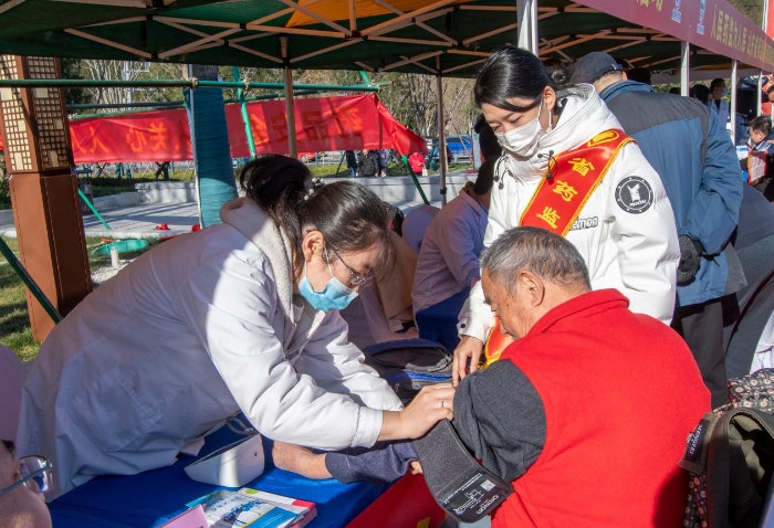 圖為醫(yī)護(hù)人員為群眾免費測量血壓并提供了健康用藥指導(dǎo)。