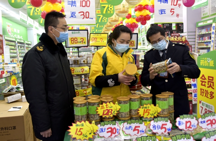 圖為1月14日監(jiān)管人員在一家藥店檢查。