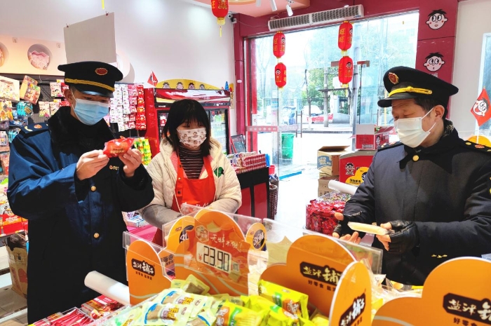 圖為執(zhí)法人員在學(xué)校周邊超市檢查兒童食品質(zhì)量。