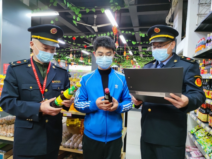 圖為執(zhí)法人員在一家超市檢查調(diào)味品質(zhì)量。