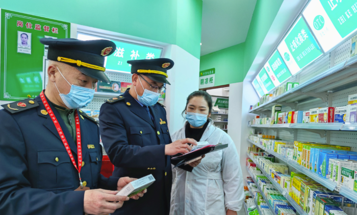 圖為執(zhí)法人員檢查“四類藥品”銷售登記情況。