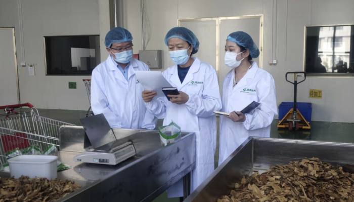 圖為執(zhí)法人員對(duì)防疫用中藥飲片質(zhì)量進(jìn)行監(jiān)督檢查。