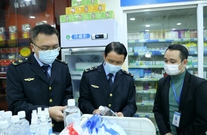 圖為執(zhí)法人員檢查口罩、酒精等防疫物資。
