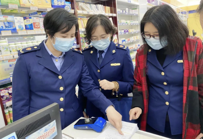圖為執(zhí)法人員檢查藥品銷(xiāo)售記錄。