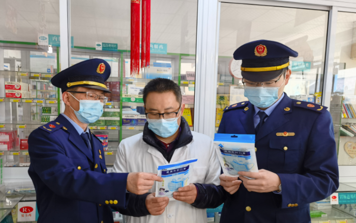 圖為執(zhí)法人員檢查藥店防疫物資。