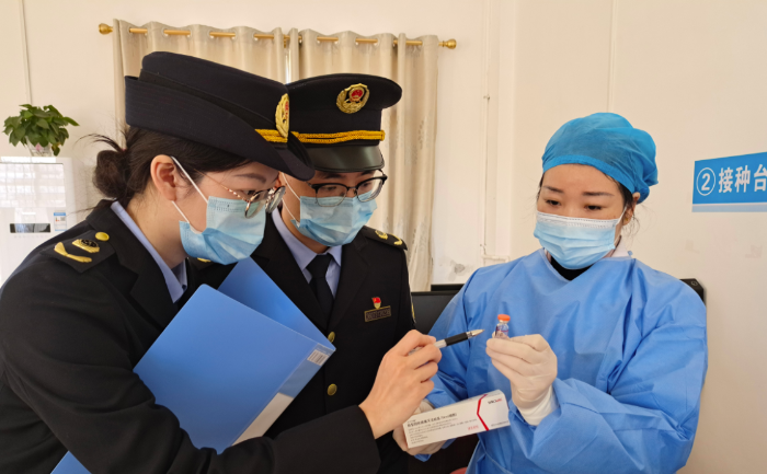 圖為執(zhí)法人員在一家醫(yī)院檢查新冠疫苗和抗原檢測試劑。