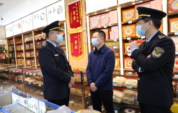秦繼紅（左一）在中藥材市場(chǎng)聽取長沙市、雨花區(qū)市場(chǎng)監(jiān)管局負(fù)責(zé)人介紹相關(guān)情況。（喻燦華 攝）
