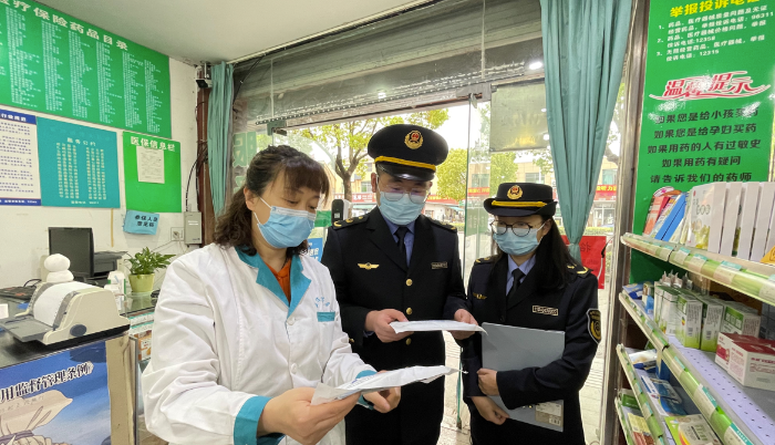 圖為執(zhí)法人員在一家藥店檢查疫情防控情況。
