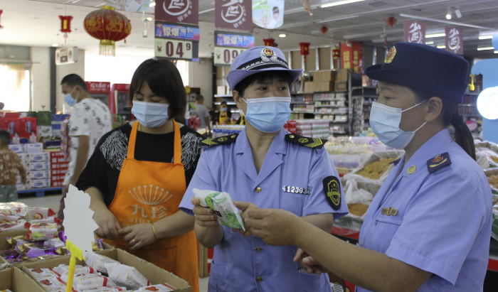 圖為執(zhí)法人員在一家商場(chǎng)食品專柜進(jìn)行執(zhí)法檢查。