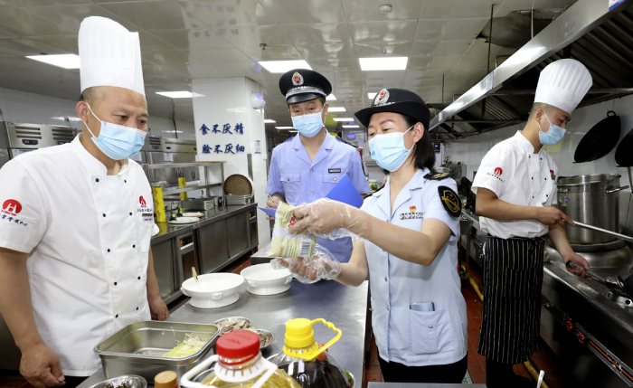 圖為淮北市市場(chǎng)監(jiān)管局執(zhí)法人員在一家學(xué)校食堂檢查食品加工環(huán)境。